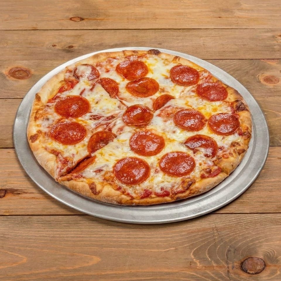 A whole pepperoni pizza from TOMATO JOE’S NEW YORK PIZZERIA on a metal pan, on a wooden table.