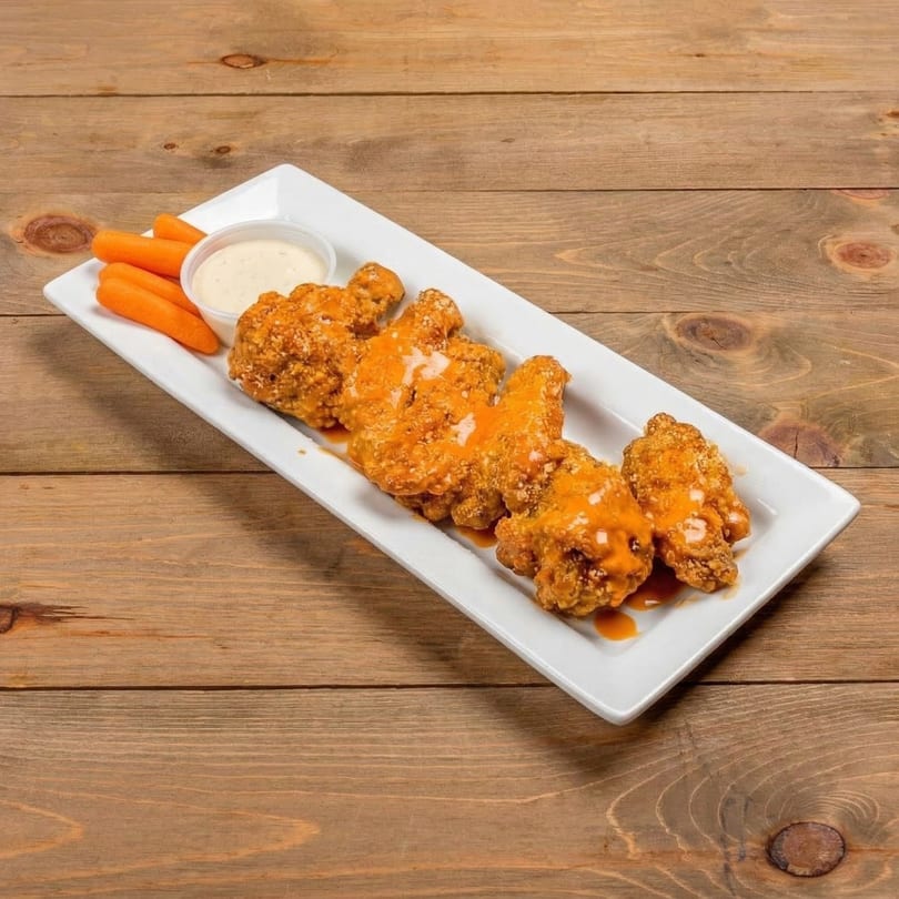 Crispy chicken wings drizzled with buffalo sauce, served with baby carrots and ranch dressing.